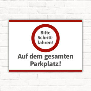 Schild Bitte Schrittfahren auf dem gesamten Parkplatz