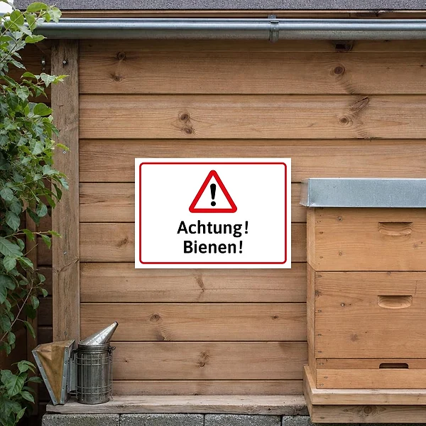 Achtung-Bienen-Warnschild an einem Imkerstand oder Grundstückseingang zur Warnung von Besuchern und Passanten vor Bienenaktivität.