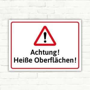 Warnschild mit Dreiecks-Warnsymbol und dem Text Achtung! Heiße Oberflächen! in Rot, Schwarz und Weiß