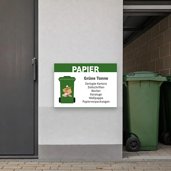Querformatiges Hinweisschild an einer Sammelstelle für Altpapier mit grüner Tonne, das Papier, Kartons und Zeitschriften für Mitarbeitende und Anwohn