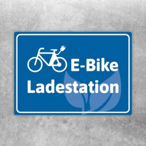 Blauer Aufkleber mit Fahrradsymbol und Text E-Bike Ladestation für Ladebereiche.
