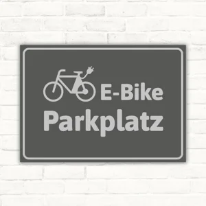Grauer Schild mit Fahrradsymbol und dem Text E-Bike-Parkplatz für Stellflächen