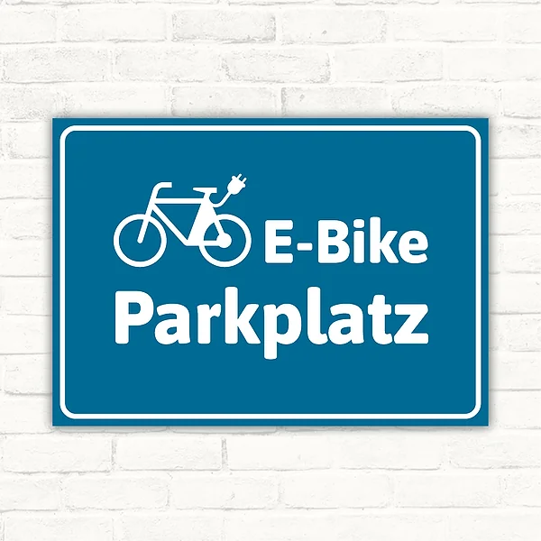 Schild E-Bike-Parkplatz blau mit Fahrradpiktogramm für klar gekennzeichnete Stellflächen.