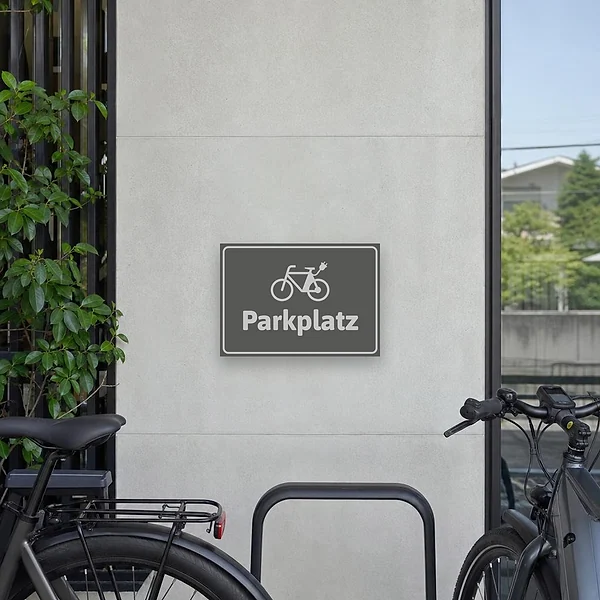 Schild E-Bike-Parkplatz grau mit Fahrradsymbol zur Kennzeichnung eines reservierten Abstellplatzes.