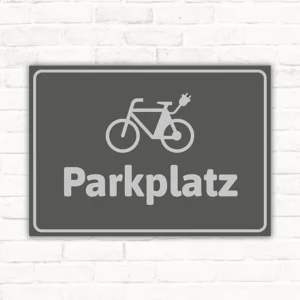Grauer Schild mit E-Bike-Symbol und dem Wort Parkplatz für klare Stellplatzkennzeichnung.