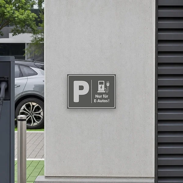Schild mit Piktogramm für E-Autos-Parkplatz und Ladehinweis in grauem Design.
