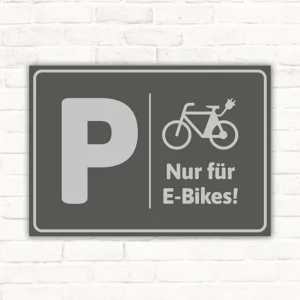 Grauer Schild mit P und Fahrradsymbol für einen E-Bike-Parkplatz.
