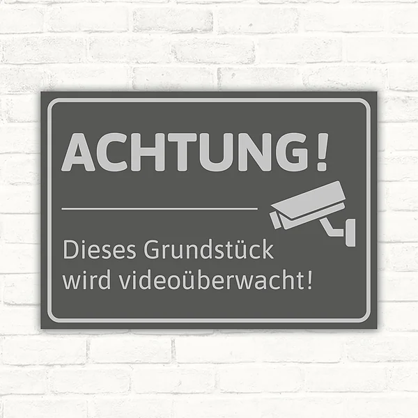 Schild mit dem Hinweis, dass ein Grundstück videoüberwacht wird, mit Kamera-Symbol.