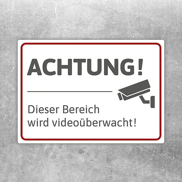 Aufkleber mit Hinweis „Achtung! Dieser Bereich wird videoüberwacht“ und Kamerasymbol.
