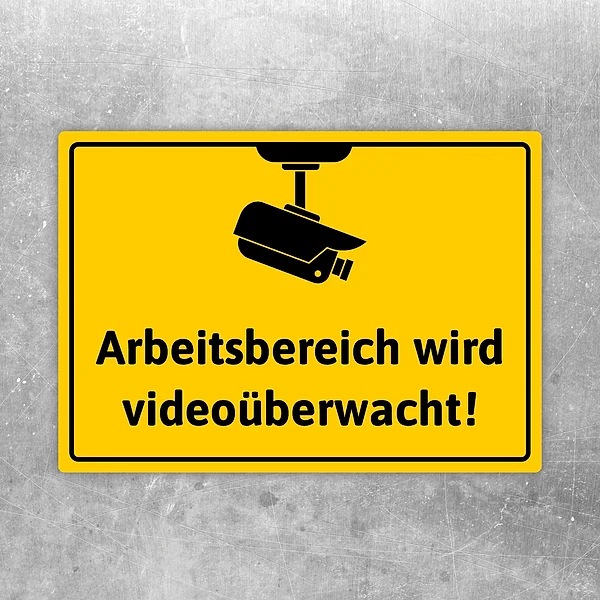 Aufkleber mit Kamerasymbol und dem Hinweis „Arbeitsbereich wird videoüberwacht“ in Gelb-Schwarz.