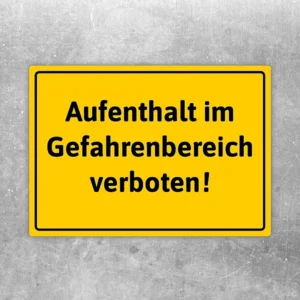 Gelber Aufkleber mit dem Text „Aufenthalt im Gefahrenbereich verboten“ als klarer Warnhinweis.