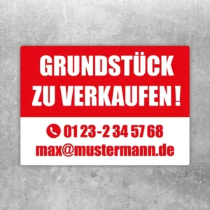 Aufkleber mit dem Hinweis „Grundstück zu verkaufen“ in roter und weißer Gestaltung.