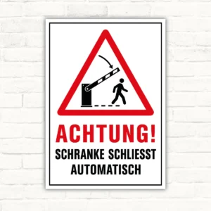 Warnschild mit rotem Dreieck und Text „ACHTUNG! SCHRANKE SCHLIESST AUTOMATISCH“ als Schild für die Einfahrt.