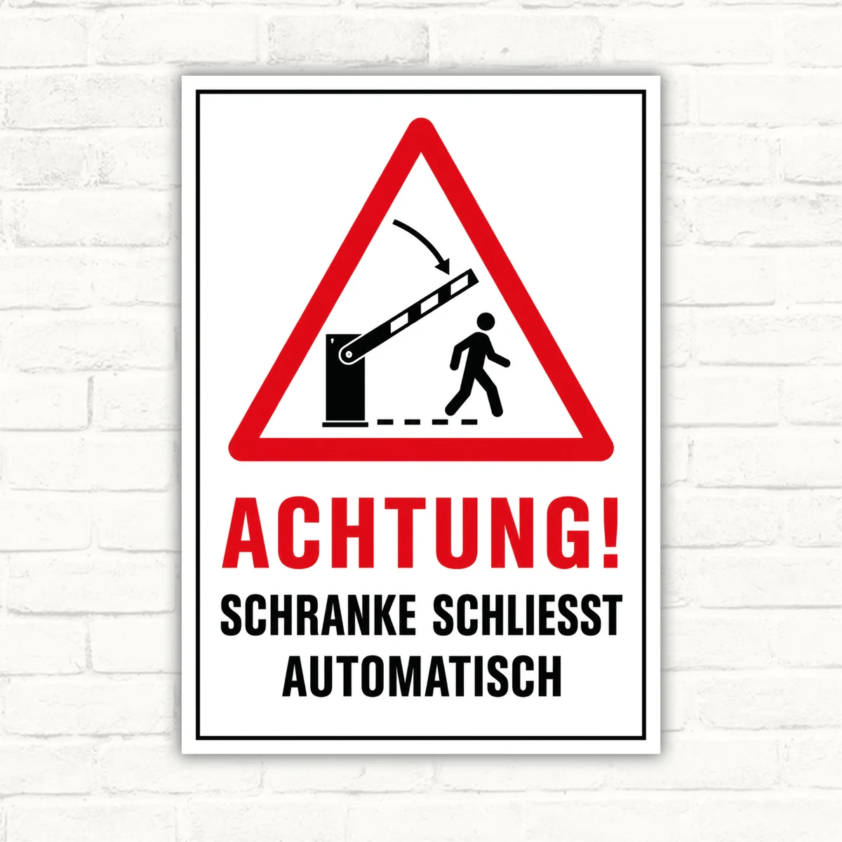 Warnschild mit rotem Dreieck und Text „ACHTUNG! SCHRANKE SCHLIESST AUTOMATISCH“ als Schild für die Einfahrt.