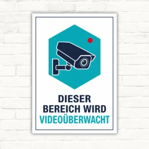Videoüberwachungsschild mit Kamera und dem Text „Dieser Bereich wird videoüberwacht“ als Hochformat-Schild.