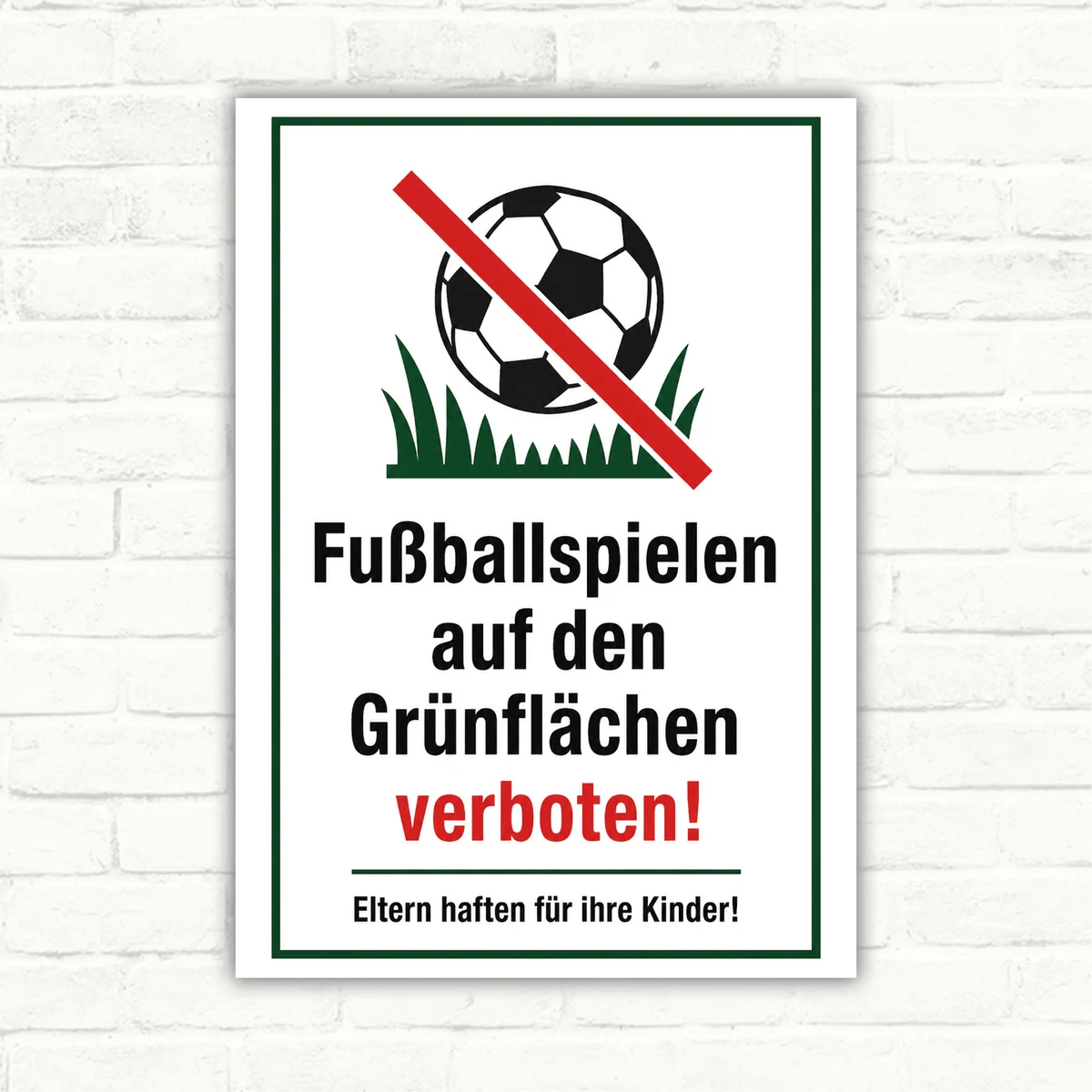 Schild mit der Aufschrift „Fußballspielen auf Grünflächen verboten“ und durchgestrichenem Fußball als Verbotsschild.