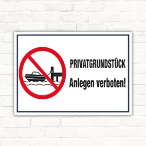 Privatgrundstück Anlegen verboten Schild mit rotem Verbotssymbol, Boot und Anlegesteg sowie dem Text „PRIVATGRUNDSTÜCK Anlegen verboten!“.
