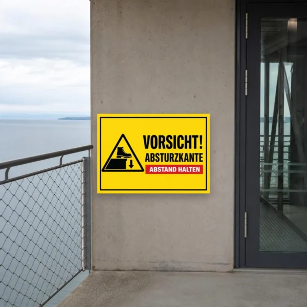 KI-generiertes Anwendungsbeispiel: Gelber Aufkleber mit Vorsicht Absturzkante und Abstand halten für sichtbare Warnmarkierung