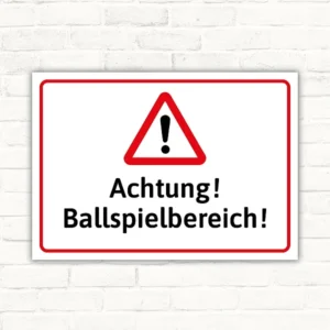 Warnschild mit Warndreieck und dem Text Achtung! Ballspielbereich!