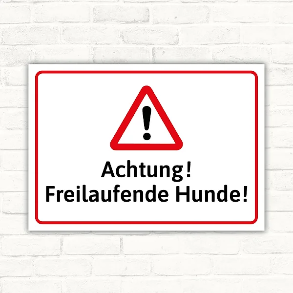 Warnschild mit rotem Dreieck und schwarzem Text „Achtung! Freilaufende Hunde!“