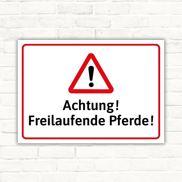 Warnschild mit dem Text Achtung! Freilaufende Pferde! und Warndreieck