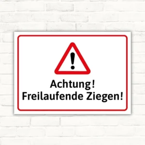 Warnschild mit dem Text „Achtung! Freilaufende Ziegen!“ und rotem Warndreieck