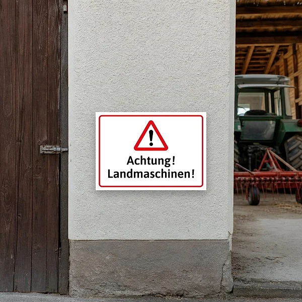 Warnschild an einer Hofeinfahrt, das auf landwirtschaftliche Fahrzeuge und Maschinenverkehr hinweist