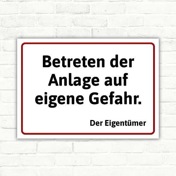 Schild mit dem Text „Betreten der Anlage auf eigene Gefahr. Der Eigentümer“ in schwarzer Schrift mit rotem Rahmen auf weißem Hintergrund.