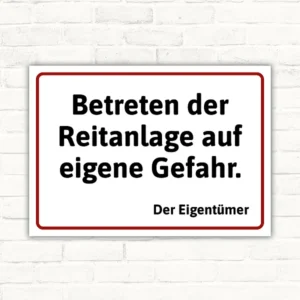 Schild mit der Aufschrift Betreten der Reitanlage auf eigene Gefahr. Der Eigentümer
