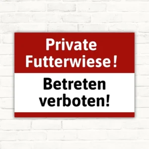 Schild mit der Aufschrift Private Futterwiese! Betreten verboten! in Rot, Weiß und Schwarz