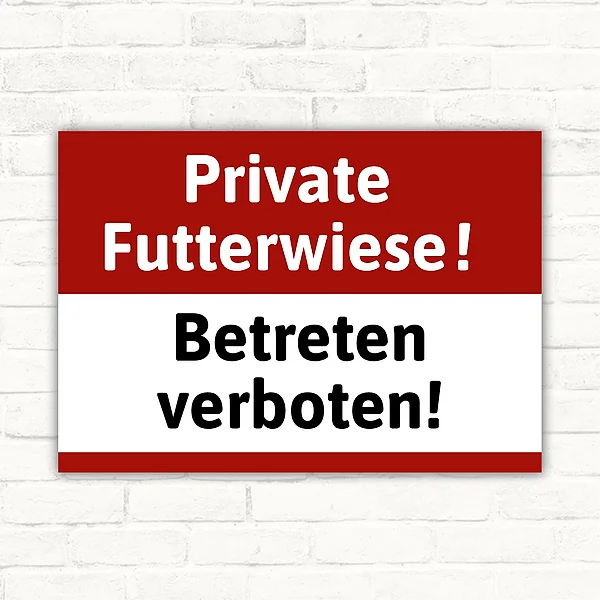 Schild mit der Aufschrift Private Futterwiese! Betreten verboten! in Rot, Weiß und Schwarz