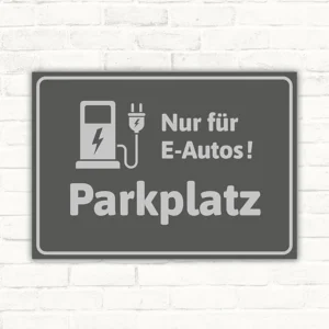 Grauer Schild mit Ladesymbol und dem Hinweis „Nur für E-Autos! Parkplatz“.