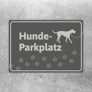 Grauer Aufkleber mit Schriftzug Hunde-Parkplatz, Hundesilhouette und Pfotenmotiv.