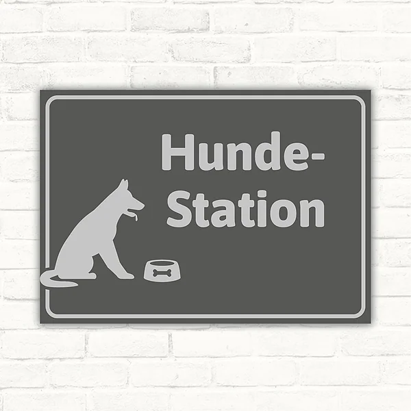 Grauer Schild mit Hundesymbol, Napf und dem Text Hundestation für den Hundebereich.