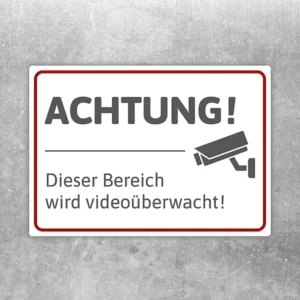 Aufkleber mit Hinweis „Achtung! Dieser Bereich wird videoüberwacht“ und Kamerasymbol.