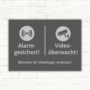 Schild mit Alarm- und Videoüberwachungssymbolen sowie dem Hinweis auf unbefugtes Betreten.