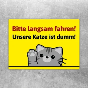 Aufkleber mit Katze und dem Hinweis: Bitte langsam fahren, unsere Katze ist dumm.