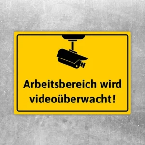Aufkleber mit Kamerasymbol und dem Hinweis „Arbeitsbereich wird videoüberwacht“ in Gelb-Schwarz.