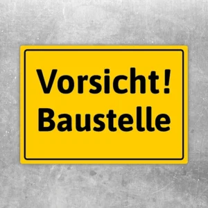 Gelber Aufkleber mit der Aufschrift Vorsicht Baustelle als klarer Warnhinweis.