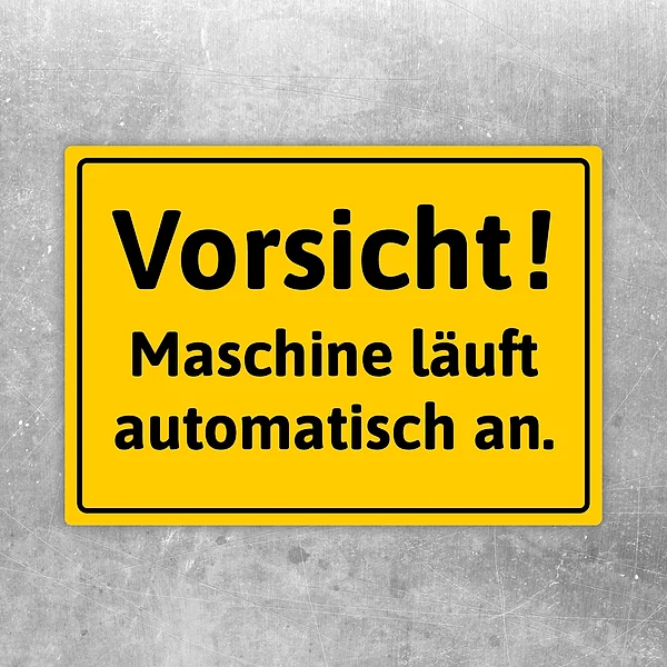 Gelber Aufkleber mit dem Hinweis „Vorsicht! Maschine läuft automatisch an.“ für Maschinenbereiche.