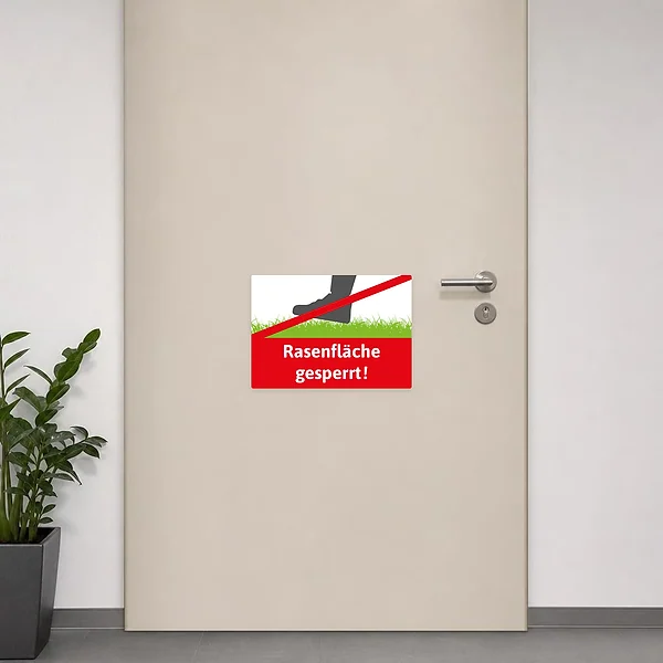 Roter Hinweisaufkleber Rasenfläche gesperrt mit Fußsymbol auf Grünfläche als klare Zugangssperre.