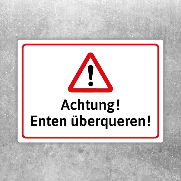 Warnaufkleber mit Dreiecksymbol und dem Text „Achtung! Enten überqueren!“ in Rot, Weiß und Schwarz.