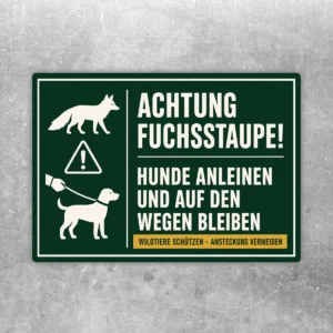 Querformatiger Aufkleber mit Fuchs-, Warn- und Hundeleinen-Symbolen sowie Text: Achtung Fuchsstaupe, Hunde anleinen und auf den Wegen bleiben.