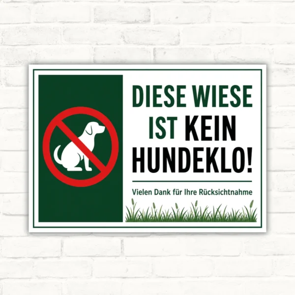 Hundeverbotsschild mit dem Text „Diese Wiese ist kein Hundeklo“ und Verbotssymbol auf weiß-grünem Schild.