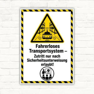 Warnschild mit Text „Fahrerloses Transportsystem – Zutritt nur nach Sicherheitsunterweisung erlaubt!“ auf gelb-schwarzem Schild.