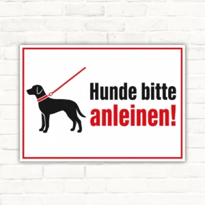 Hunde bitte anleinen Schild mit Hundesilhouette und rotem Hinweistext auf weißem Hintergrund als Hinweisschild aus Alu-Verbund.