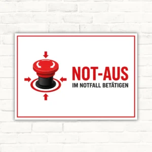 Bedrucktes Schild mit rotem Not-Aus-Taster und Text „Not-Aus im Notfall betätigen“ auf weißem Hintergrund.