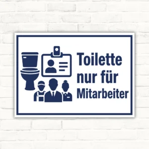 Schild mit Aufdruck „Toilette nur für Mitarbeiter“, blaues Hinweisschild für den Personalbereich mit Piktogrammen.