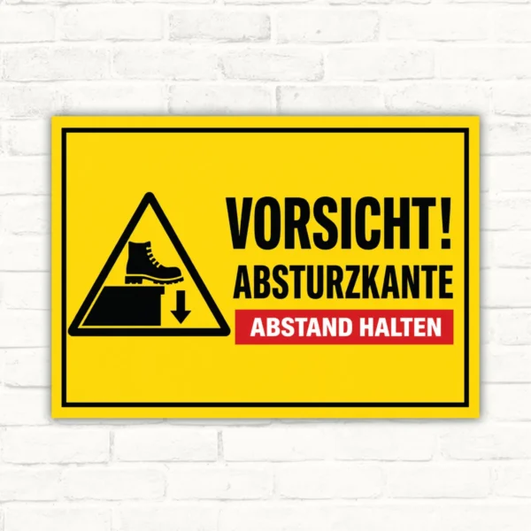 Warnschild mit der Aufschrift „Vorsicht! Absturzkante Abstand halten“ in Gelb-Schwarz als Aluminium-Schild.