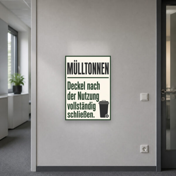KI-generiertes Anwendungsbeispiel: Mülltonnen Schild „Deckel nach der Nutzung vollständig schließen“ an heller Wand.